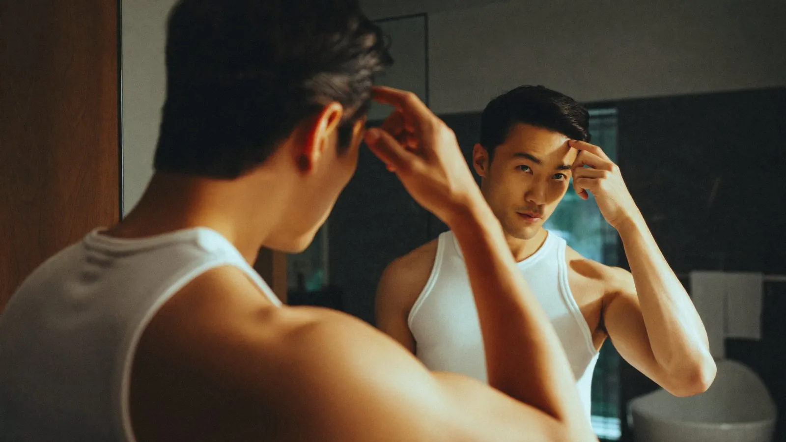 Dr Sin Yong describing the early signs of male hair thinning at the hairline and crown