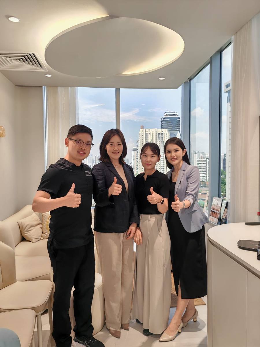 Dr Sin Yong with HIRONIC Korean headquarters team at his aesthetic practice on Orchard Road, Singapore, October 2025 — city skyline visible